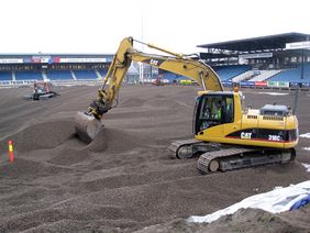 An excavator distributing the expanded clay